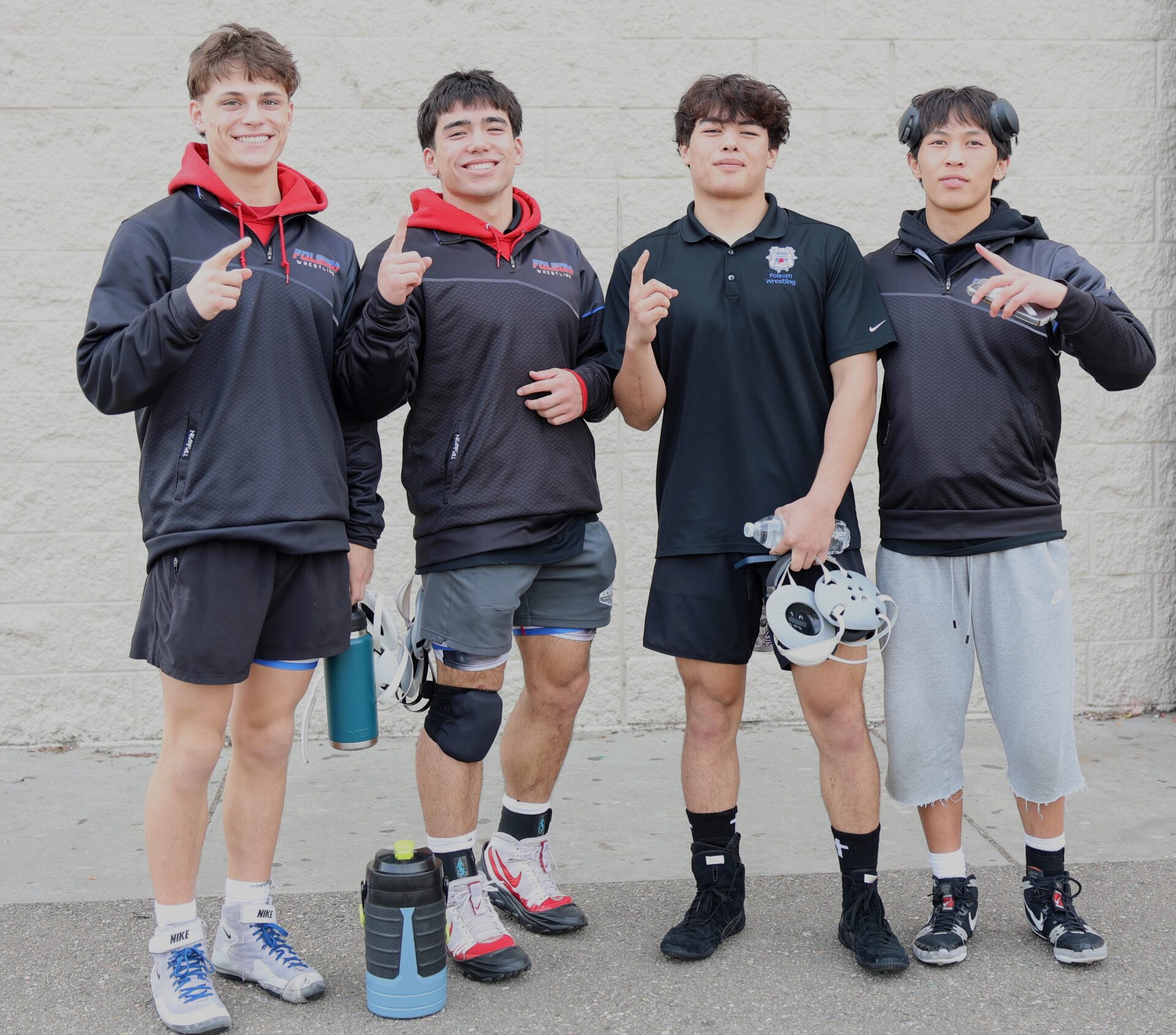 Four Folsom wrestling teammates standing together at a tournament